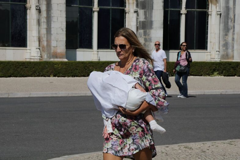 Atrás de Liliana Aguiar, o bebé Salvador, ao colo da madrinha